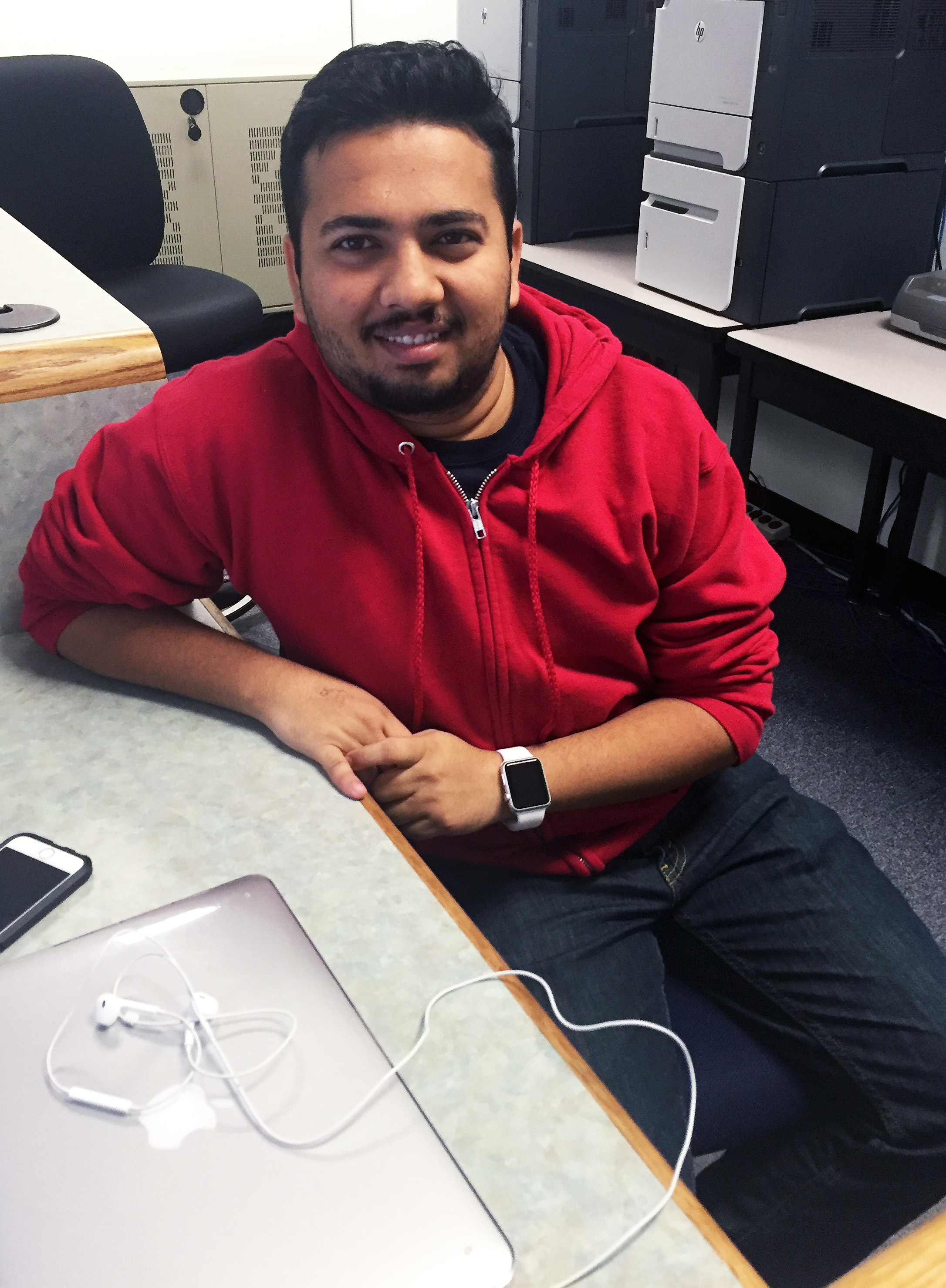 Image: Harsh Naik, business and healthcare administration graduate student, works behind the desk in the Bayou Building open computer lab. Photo by The Signal reporter Chelsea Colombo.