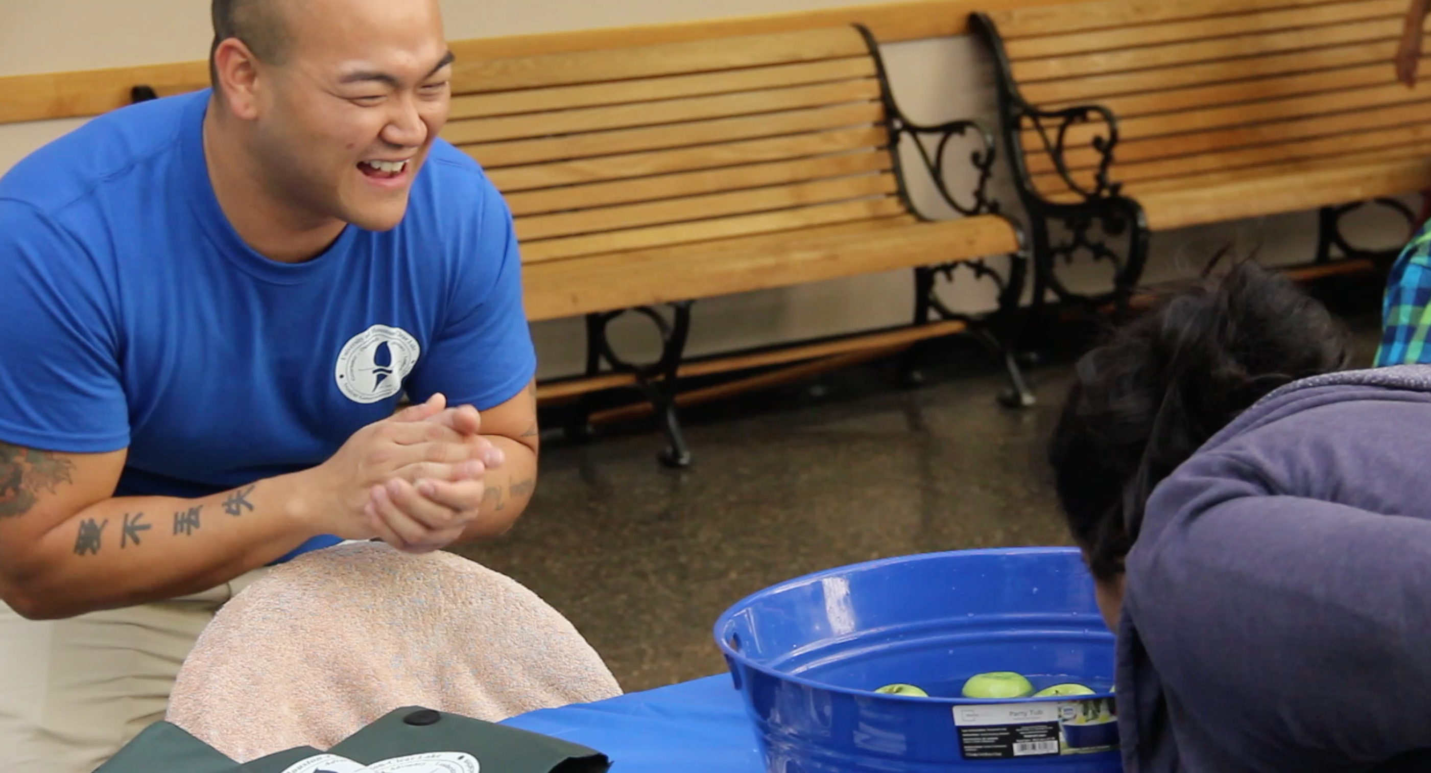 Image: SGA committee coordinator Tri Nguyen encourages a student bobbing for apples at the SGA booth at the 2015 I Heart UHCL Day. Photo by The Signal reporter Kyle Harrison.