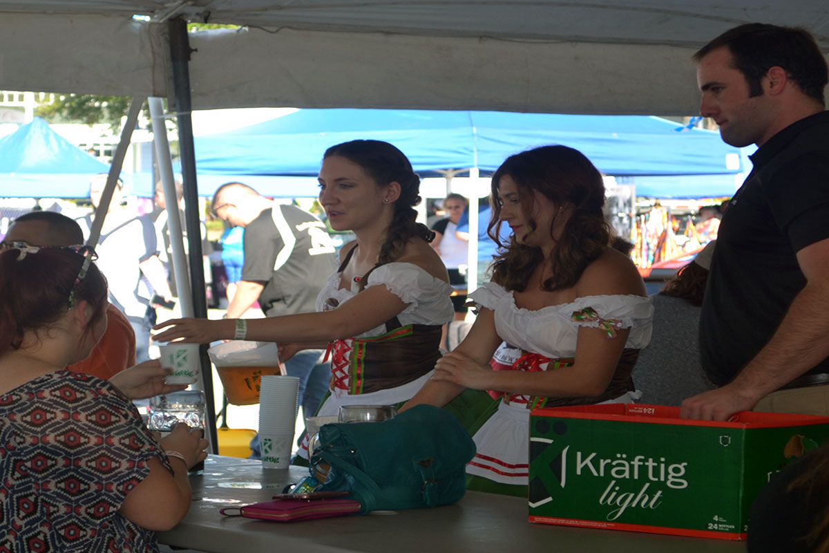 Image: The Kraftig girls hand out beer samples to festivalgoers at the Kemah Oktoberfest. Photo by The Signal reporter Jaclynn Abatecola