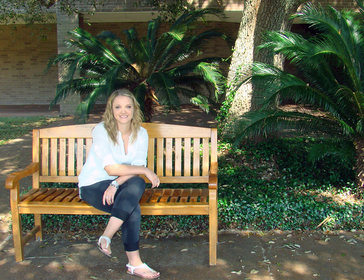 Image: Sammi Sanders, UHCL Alumni sitting on a bench at Alvin Community College. Photo by The Signal reporter Kyle Upton.