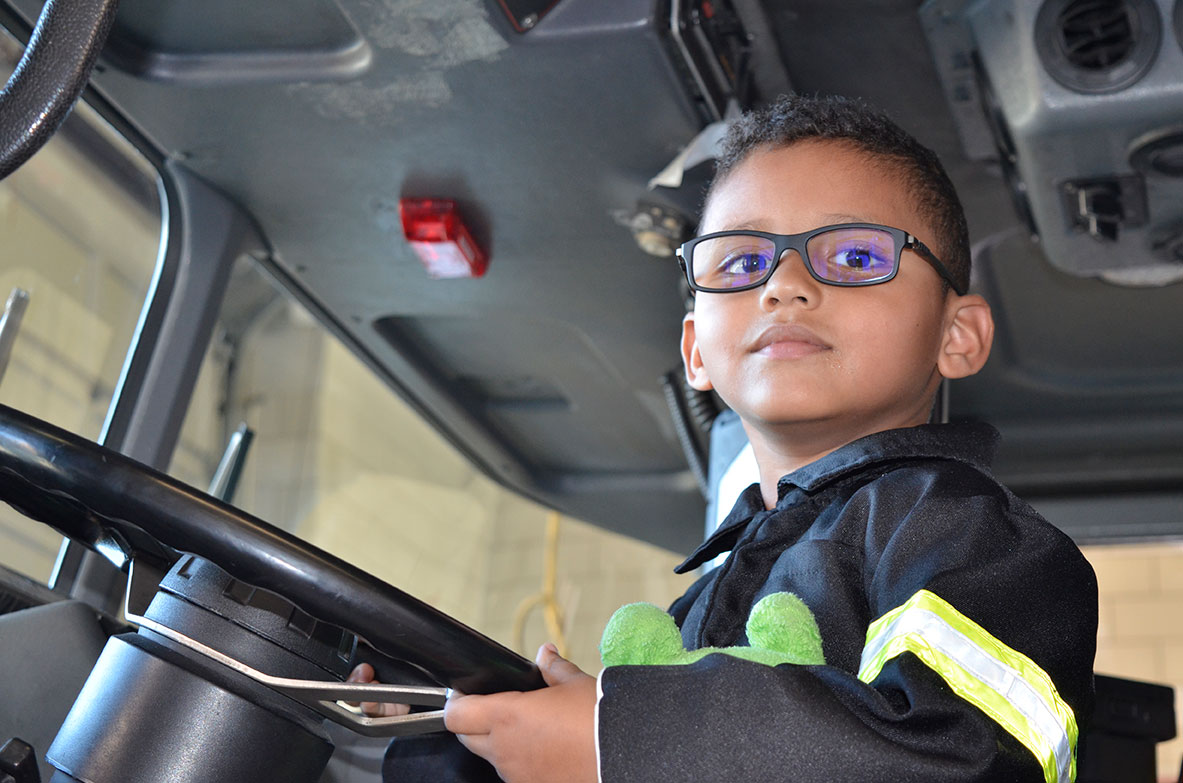 Parker Lococo sitting in the driver's seat of a firetruck. Photo by The Signal reporter Amy Diaz Hollis.