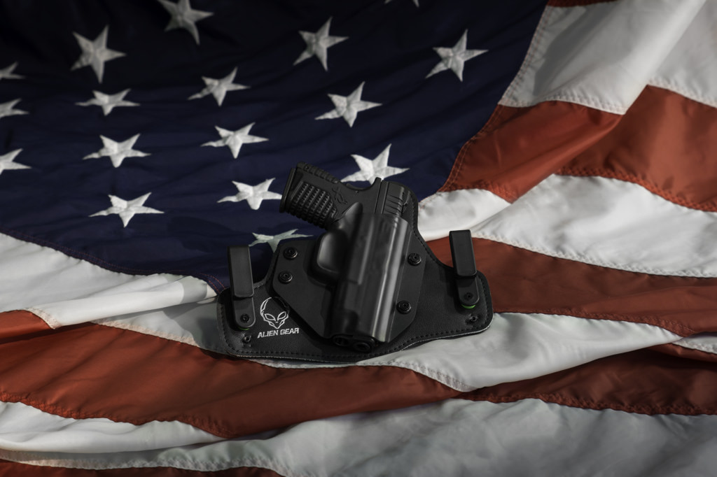 Handgun laying on top of a sprawled out American flag.