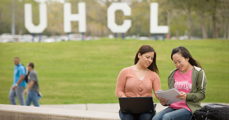 This image shows two students having a conversation in front of the UHCL letters. Photo courtesy of the UHCL Office of Communication.
