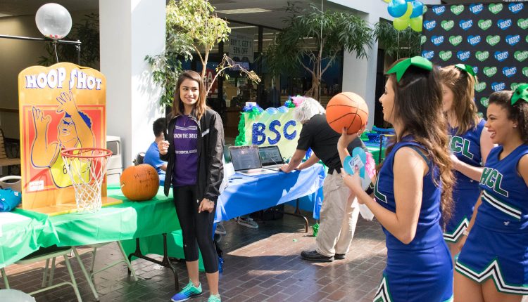 UHCL Spirit Squad member, Enely Alanis, playing mini basketball at the American Dental Association (ADS) booth with ADS member, Meghan Bhakta, at the 2017 I Heart UHCL Day event. Photo by Audience Engagement Coordinator Regan Bjerkeli.