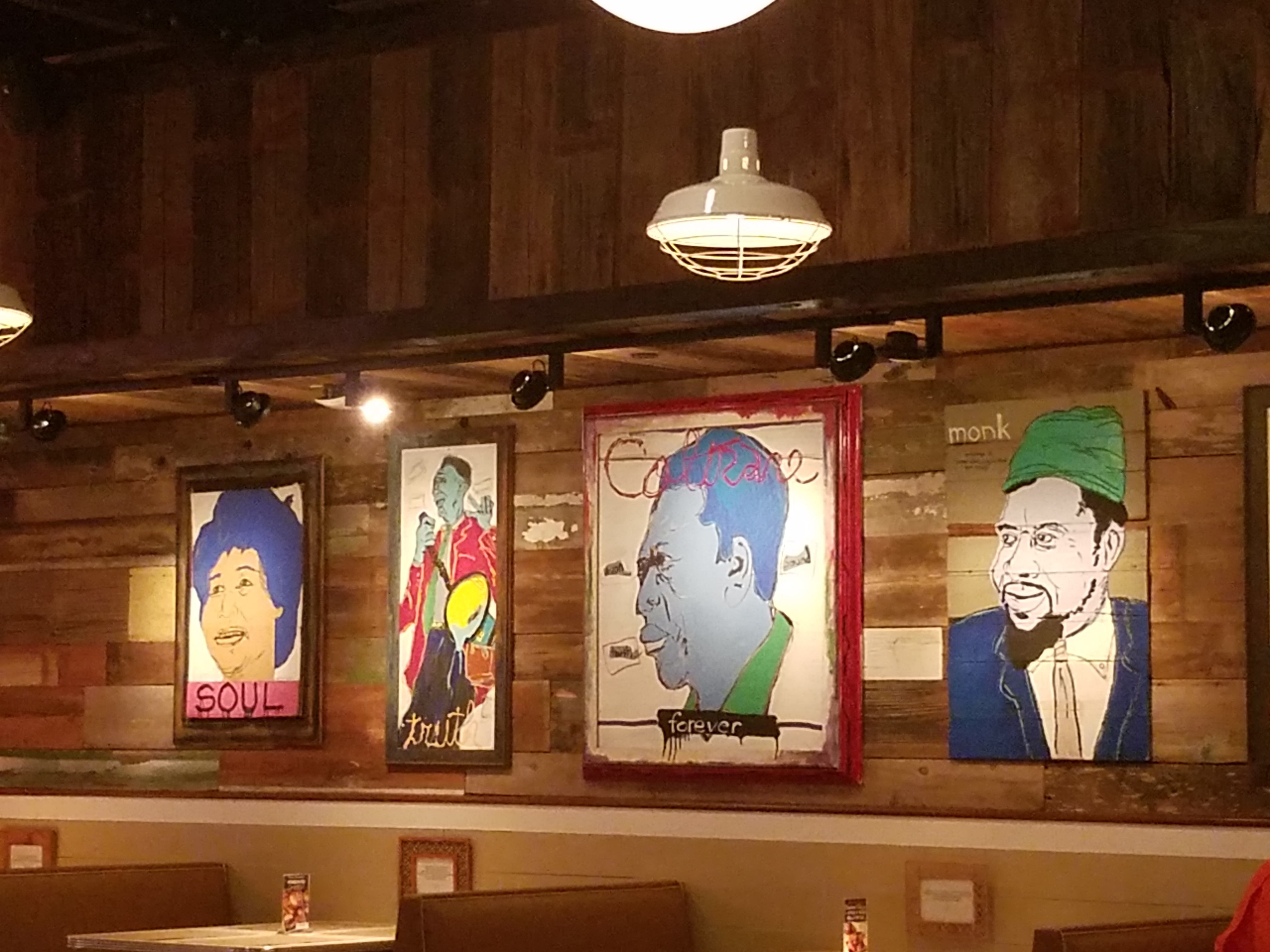Colorful artwork featuring famous jazz musicians line the wall of the dining area. Photo by The Signal reporter Bianca Salazar.