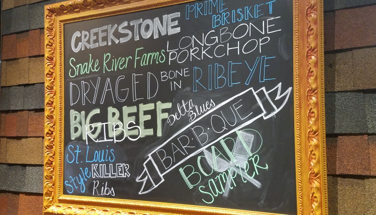A chalkboard sign outside the restaurant featuring signature menu items. Photo by The Signal reporter Bianca Salazar.