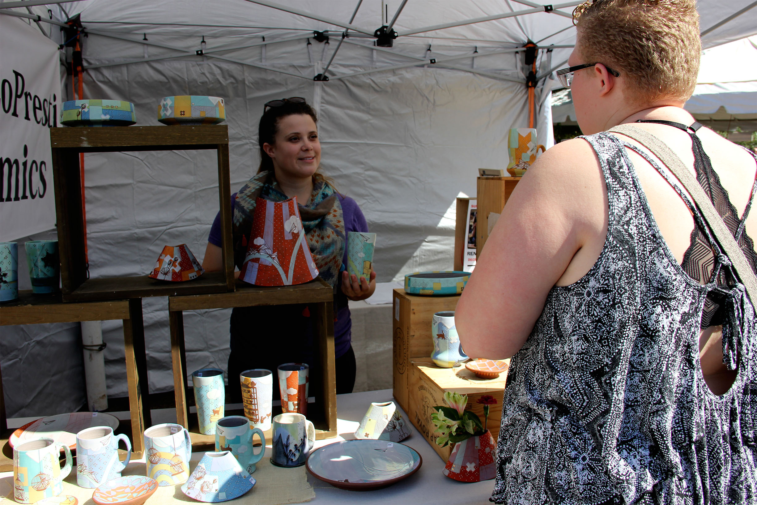PHOTO: One of the youngest artists accepted this year, Renee LoPresti talks with a festival guest about her work. Photo by The Signal Online Editor Alyssa Shotwell.