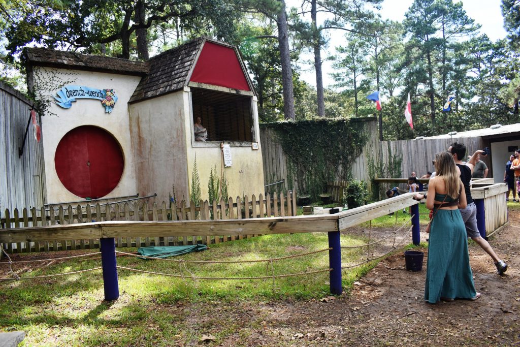 PHOTO: Spectators at the Texas Renaissance Festival test their throwing skills at Drench-A-Wench as the wench on a bench taunts them with crude jokes. Photo courtesy of Matthew Smith