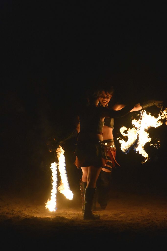 PHOTO: Fire Dancer Audi Houswerth smiles seductively as she and another dancer perform their routine with the fire performance group Solar Rain. Photo courtesy of Matthew Smith