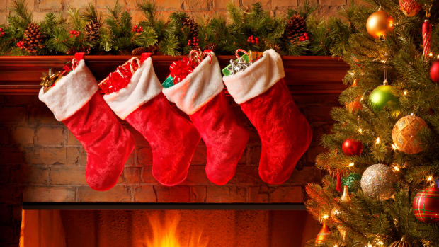 PHOTO: Christmas stockings filled next to Christmas tree. Photo courtesy of History.com.