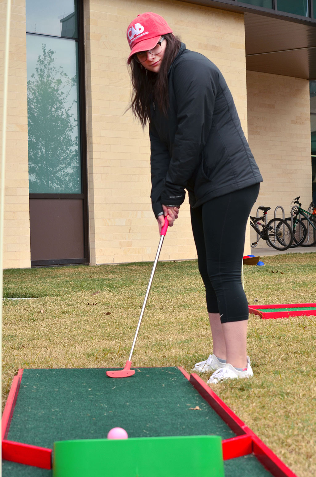 PHOTO: Leslie Chapa, a member of the Campus Activities Board, makes the winning shot on a particularly trying hole of the putt-putt golf course set up during the Jan. 30, 2019 Winter Wonderland celebration on the UHCL campus between the new STEM building and rec center. Photo by The Signal reporter Jennifer Martinez.