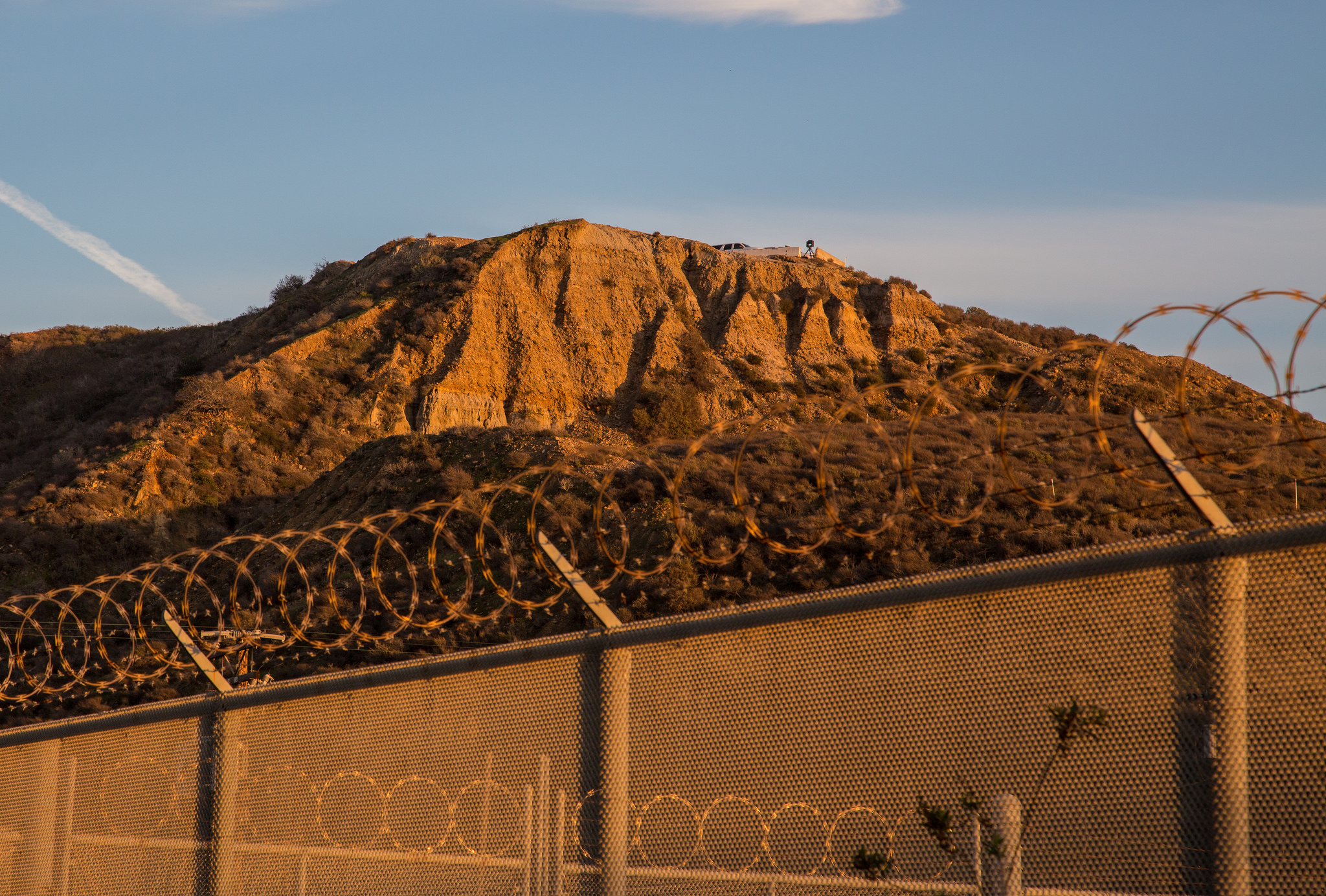 PHOTO: A barbed wire fence at the border between U.S. and Mexico. Photo by Tony Webster