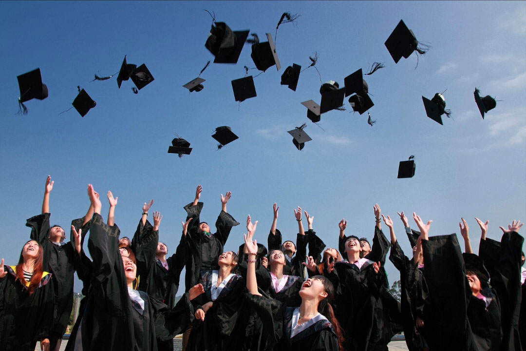PHOTO: Students celebrate graduation, with the classic cap throw in the air. Photo courtesy of Canva.