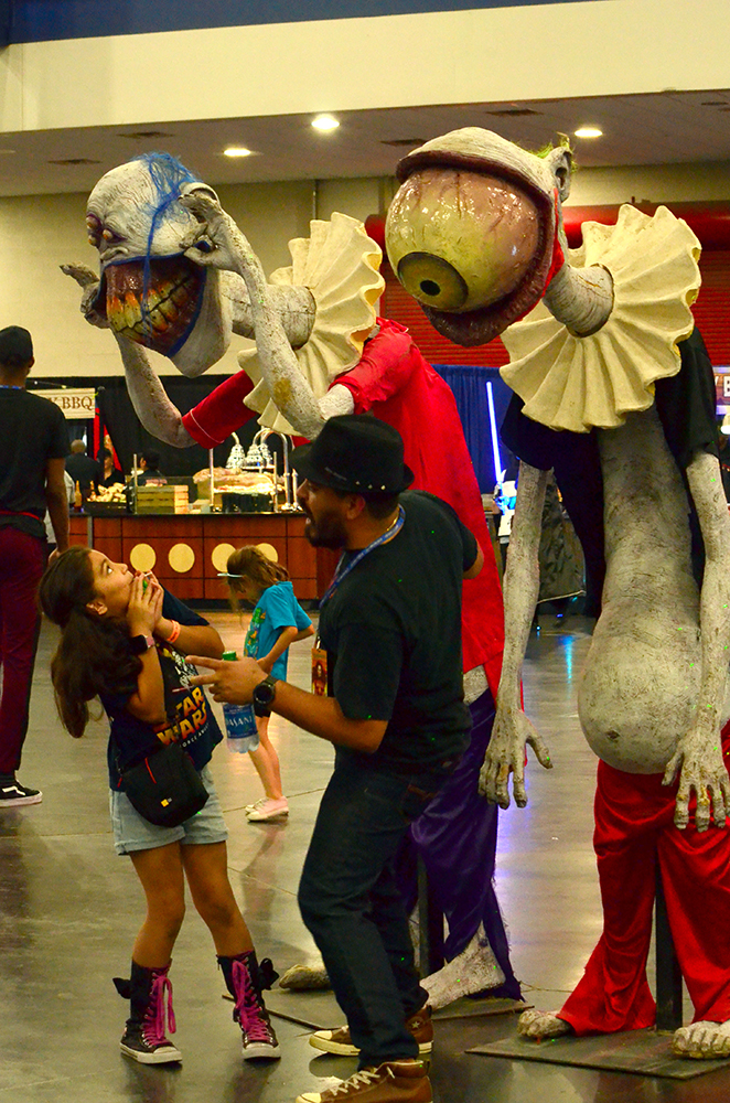 PHOTO: A young girl and her father react to scary and disturbing-looking clown statues. Photo by The Signal reporter Jennifer Martinez.