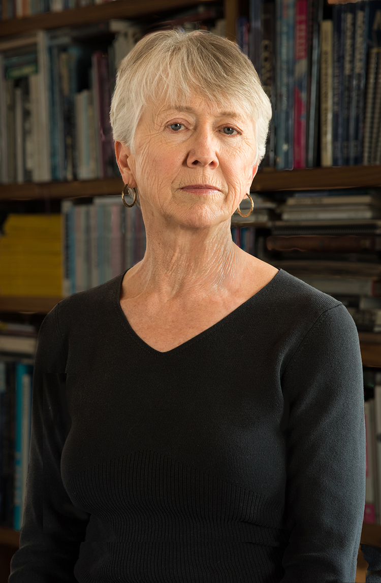 PHOTO: Author Patricia Eagle poses for headshot in a black sweater in front of a filled bookshelf. Photo courtesy of JKS Communications.