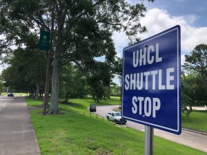 PHOTO: Blue sign reading "UHCL Shuttle Stop." Photo by Co-Managing Editor Miles Shellshear.