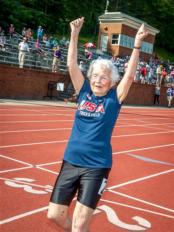 PHOTO: Julia "Hurricane" Hawkins with her hands up crossing the finish line. Photo courtesy of the National Senior Games Association.