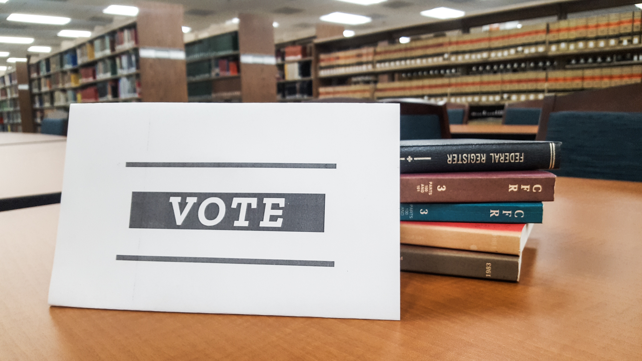 PHOTO: A vote sign placed against books in library. Photo by The Signal Reporter Aldana Reyes.