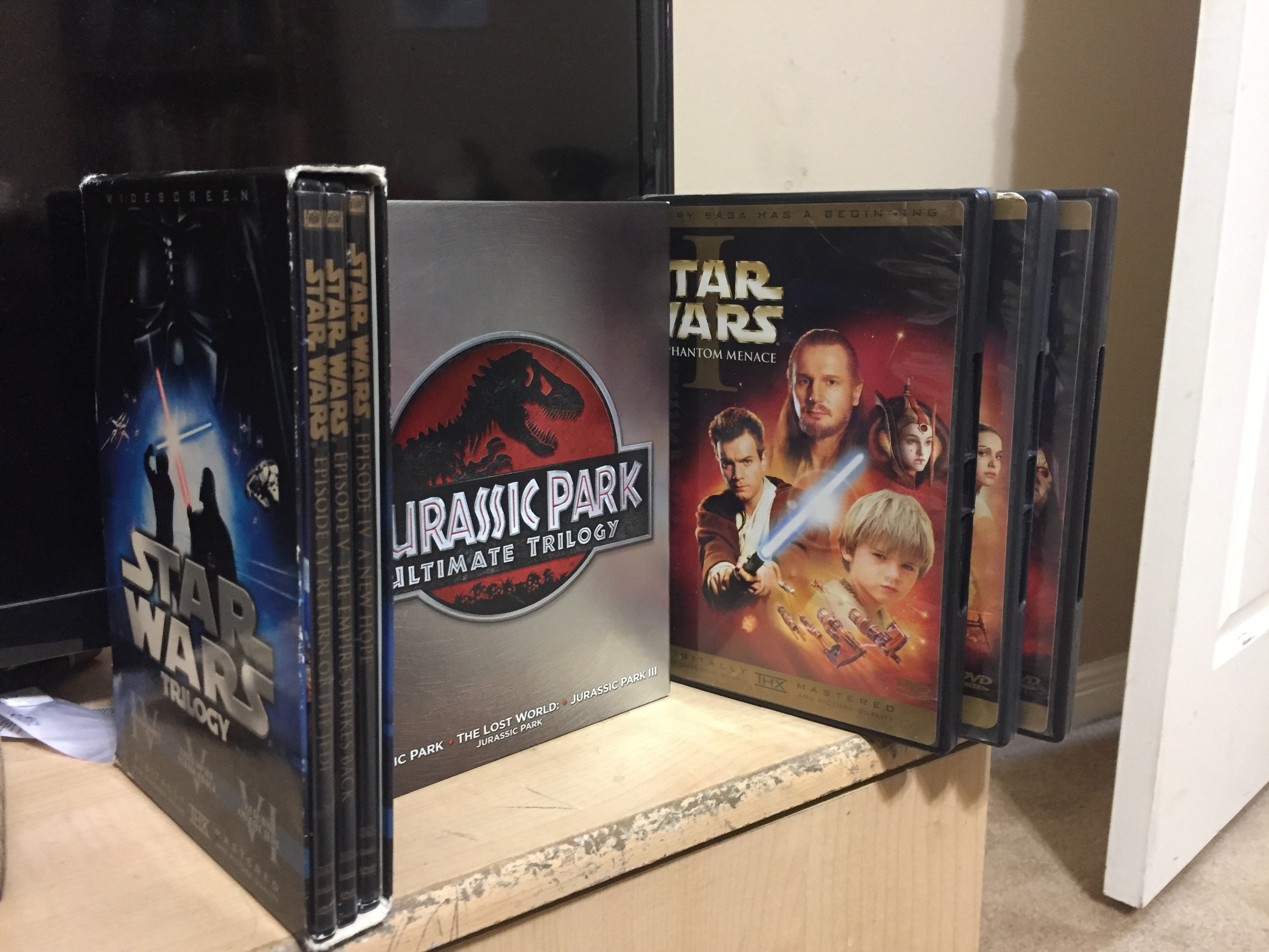 PHOTO: Image showing the box set for the original "Star Wars" trilogy, the "Jurassic Park Ultimate Trilogy" set and the three "Star Wars" prequel films on a television desk. Photo by The Signal managing editor Troylon Griffin II.