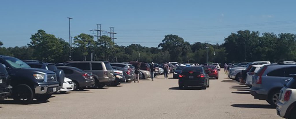 PHOTO: Image depicts UHCL's student parking lot during one of its busiest days on campus. Cars line up on a sunny day as they wait for a parking space to become available. Photo by The Signal reporter Mirian Umana.