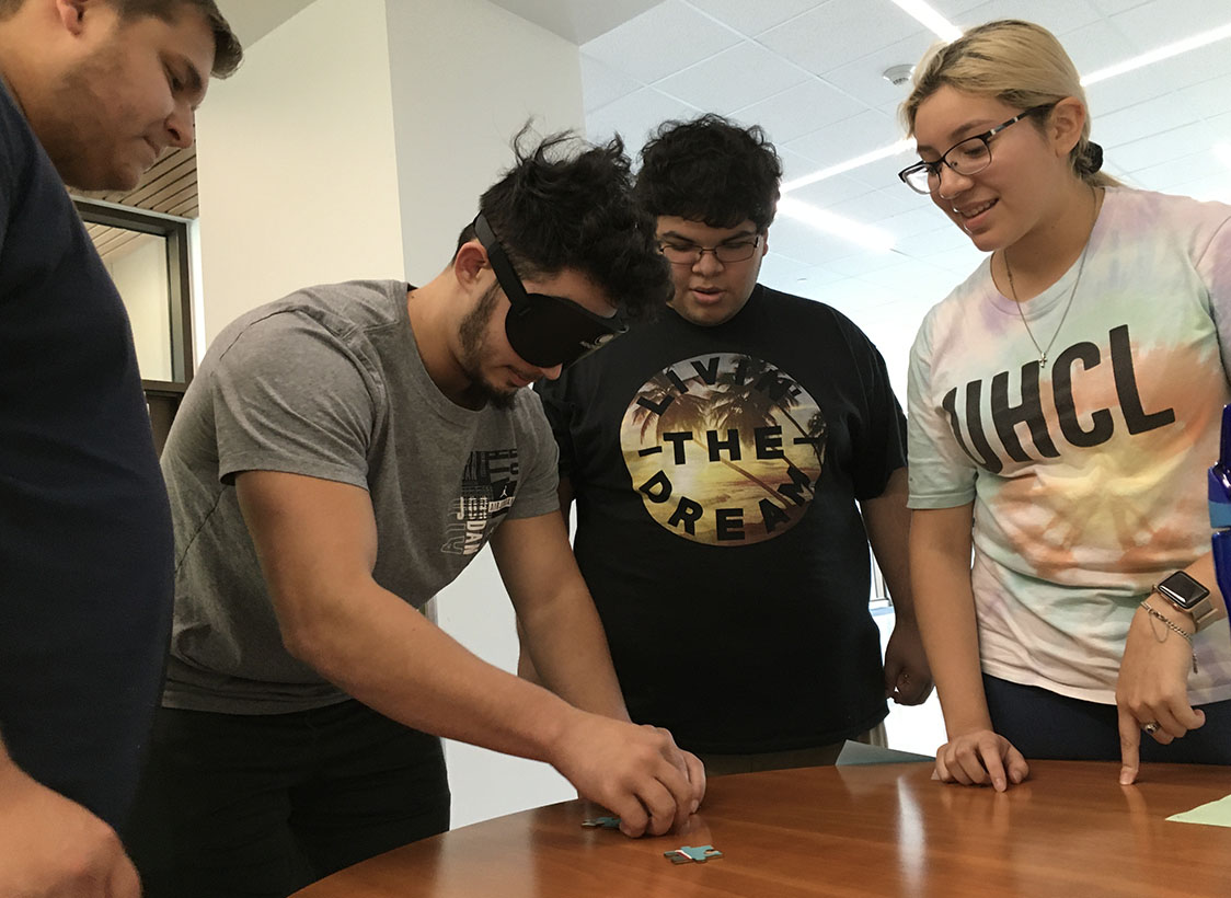 PHOTO: Michael Stump, Buck Khalil, Christopher Garcia, and Anahi Aguirre play a blindfolded puzzle game. Photo by The Signal reporter Demetria Ledesma.