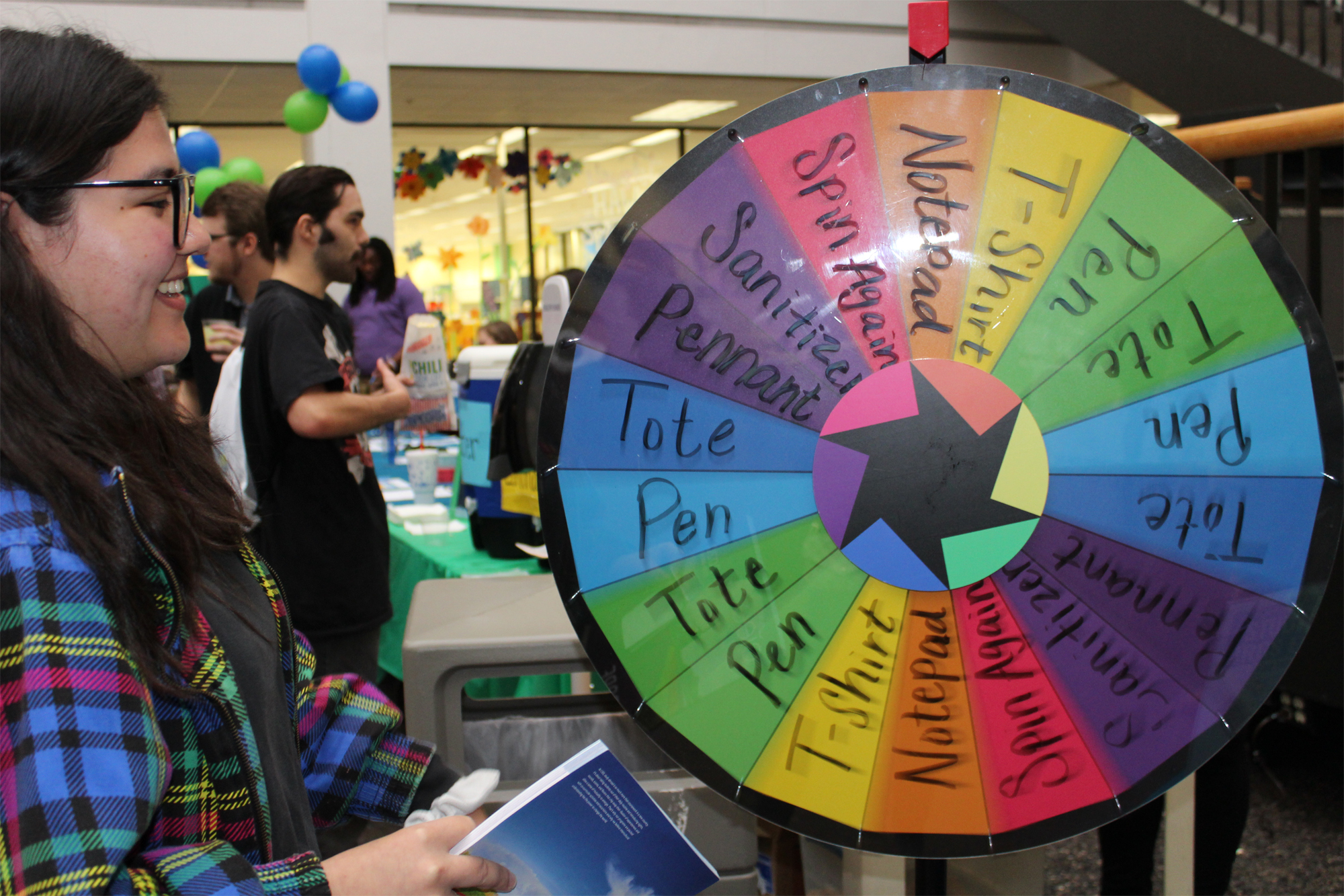PHOTO: Student spins a game wheel to win a prize. Photo by: The Signal reporter Aimee Kubena.