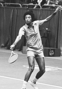 PHOTO: Ashe at the 1975 World Tennis Tournament in Rotterdam. Photo courtesy of the Creative Commons & Dutch National Archives. SOURCE: https://www.nationaalarchief.nl/onderzoeken/fotocollectie/ac62bf74-d0b4-102d-bcf8-003048976d84