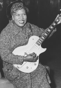 PHOTO: Sister Rosetta Tharpe playing her guitar. Photo courtesy of the Associated Press. SOURCE: https://www.knkx.org/post/godmother-rock-n-roll-seattle-rep-celebrates-sister-rosetta-tharpe-new-musical