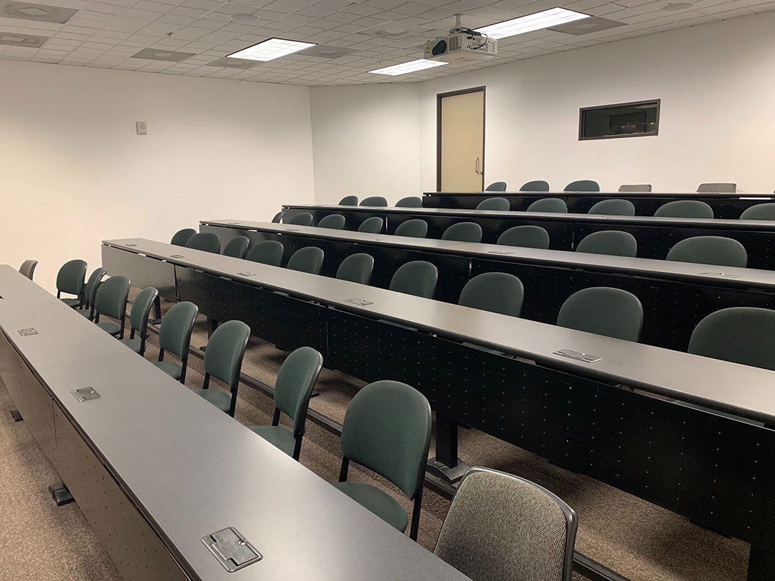 PHOTO: Image depicts empty classroom with multiple chairs against several connected tables at the University of Houston Clear Lake. Photo by The Signal Editor-in-Chief Brandon Pena.