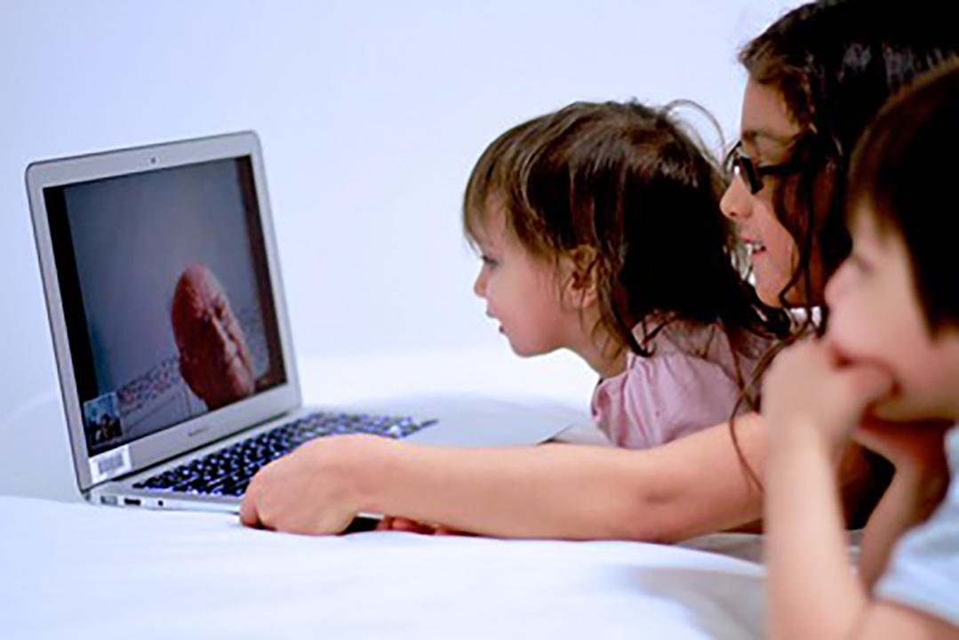 PHOTO: Image of children looking at a video call on the computer from their grandfather. Photo courtesy of Alec Couros (CC BY-NC-SA 2.0)