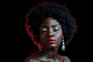 PHOTO: A Black woman with sparkly eyeshadow closing her eyes with a black background. Photo courtesy of Bestbe Models via Pexels.com. SOURCE: https://www.pexels.com/photo/woman-closing-her-eyes-1977292/