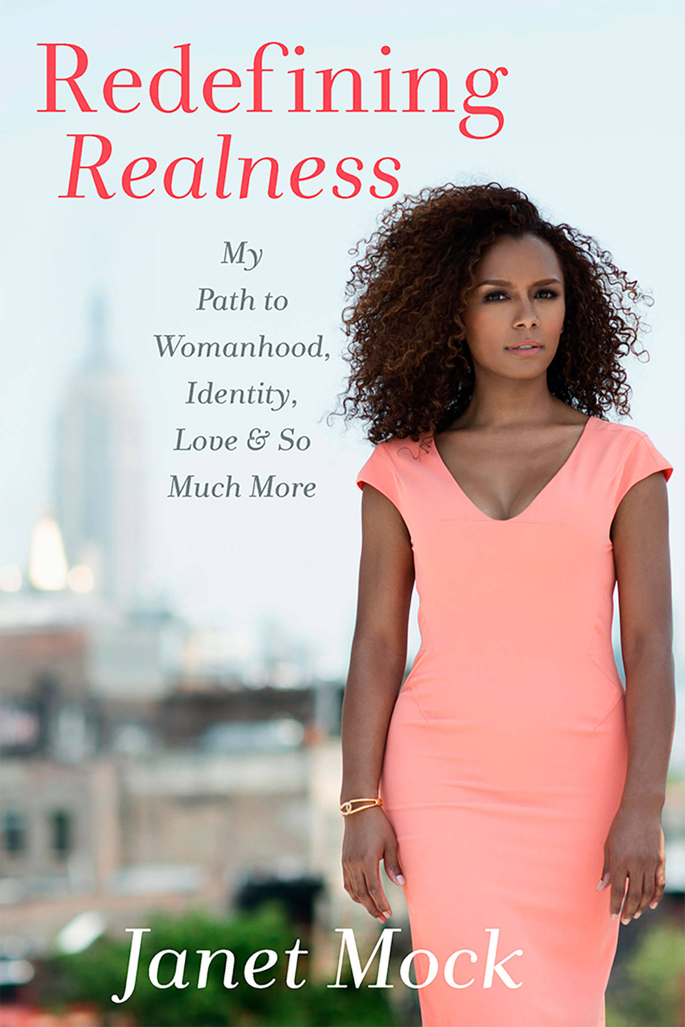 COVER: Woman with a pink dress standing in front of the city. The text "Redefining Realness" are above the woman with the author's name at the bottom. Book cover courtesy of janetmock.com. SOURCE: https://janetmock.com/books/