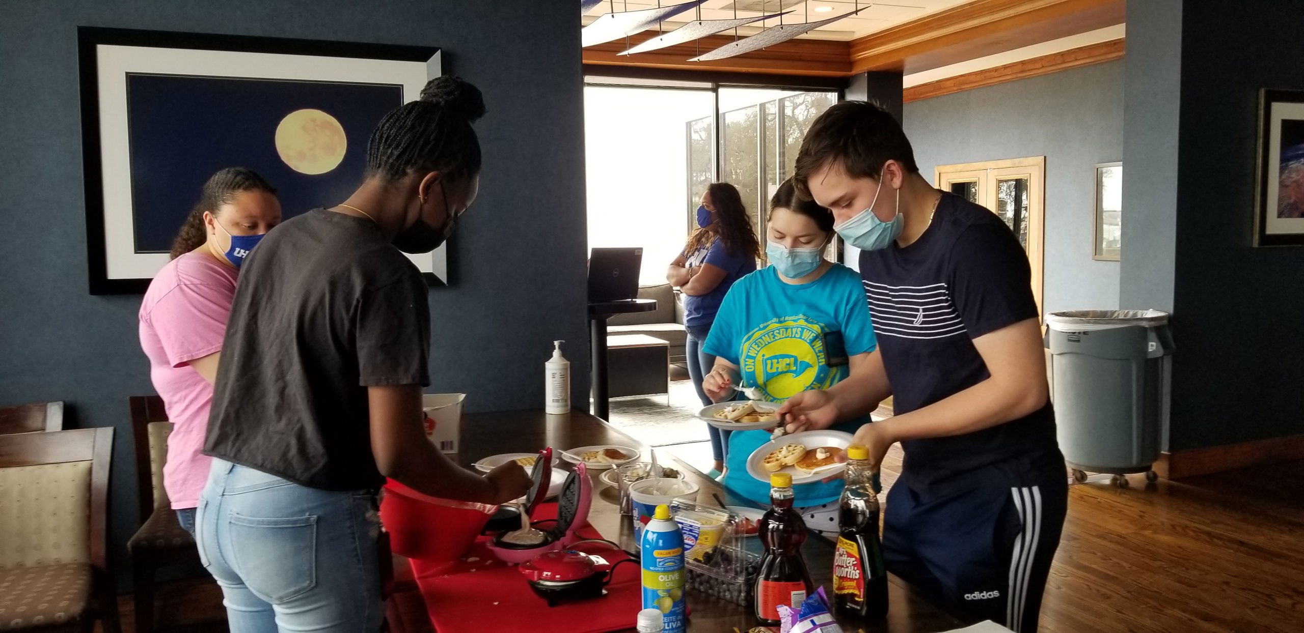 PHOTO: Cierra Davis, residential life coordinator, Nayla Coureur, resident advisor and Hunter Hall residents Danna Almazan, Arleth Gonzalez, and Ilkka Halmari partake in a waffle bar event hosted at the Hilton Houston NASA Clear Lake. Photo courtesy of UHCL Student Housing and Residence Life.