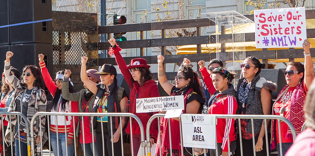 PHOTO: Women at the San Fransico Womrn's March calling attention to missing Indigenous women. Photo courtesy of Pax Ahimsa Gethen via Flickr. SOURCE: https://commons.wikimedia.org/wiki/File:Women%27s_March_SF_20180120-9762.jpg
