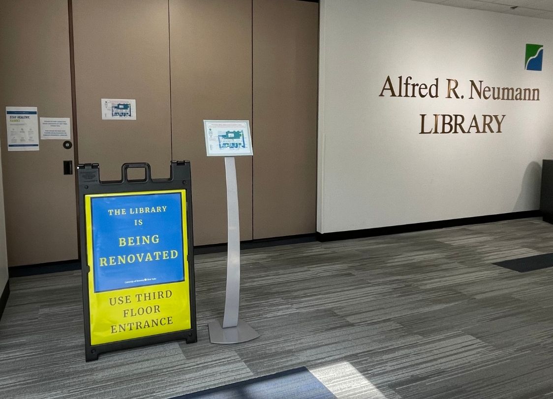 PHOTO: Main entrance to Alfred R. Neumann Library with doors closed and sign in front that says "The library is being renovated use third floor entrance" in capital letters. Photo courtesy of Audience Engagement Editor Stephanie Perez
