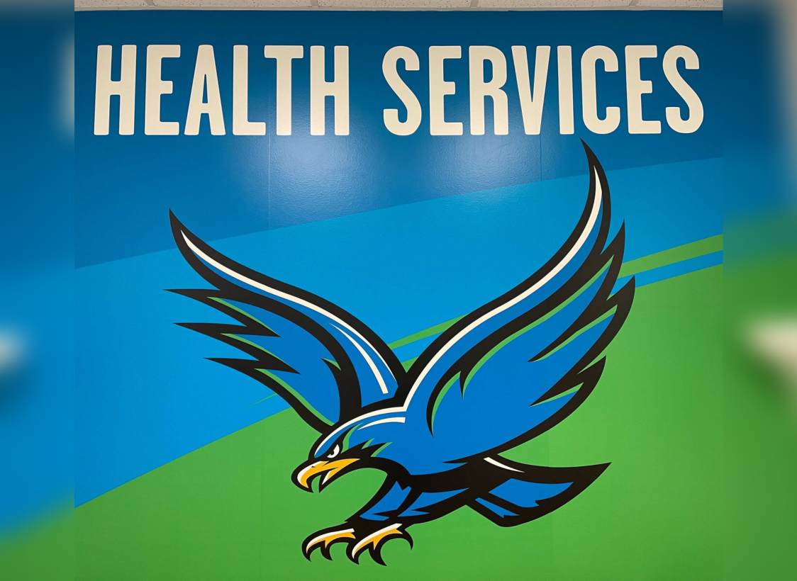 PHOTO: Image depicts UHCL Hawk logo against a blue and green backdrop. Above are the words, “HEALTH SERVICES.” Health Services mural located in the Health Services office. Photo by The Signal Managing Editor of Content & Operations.