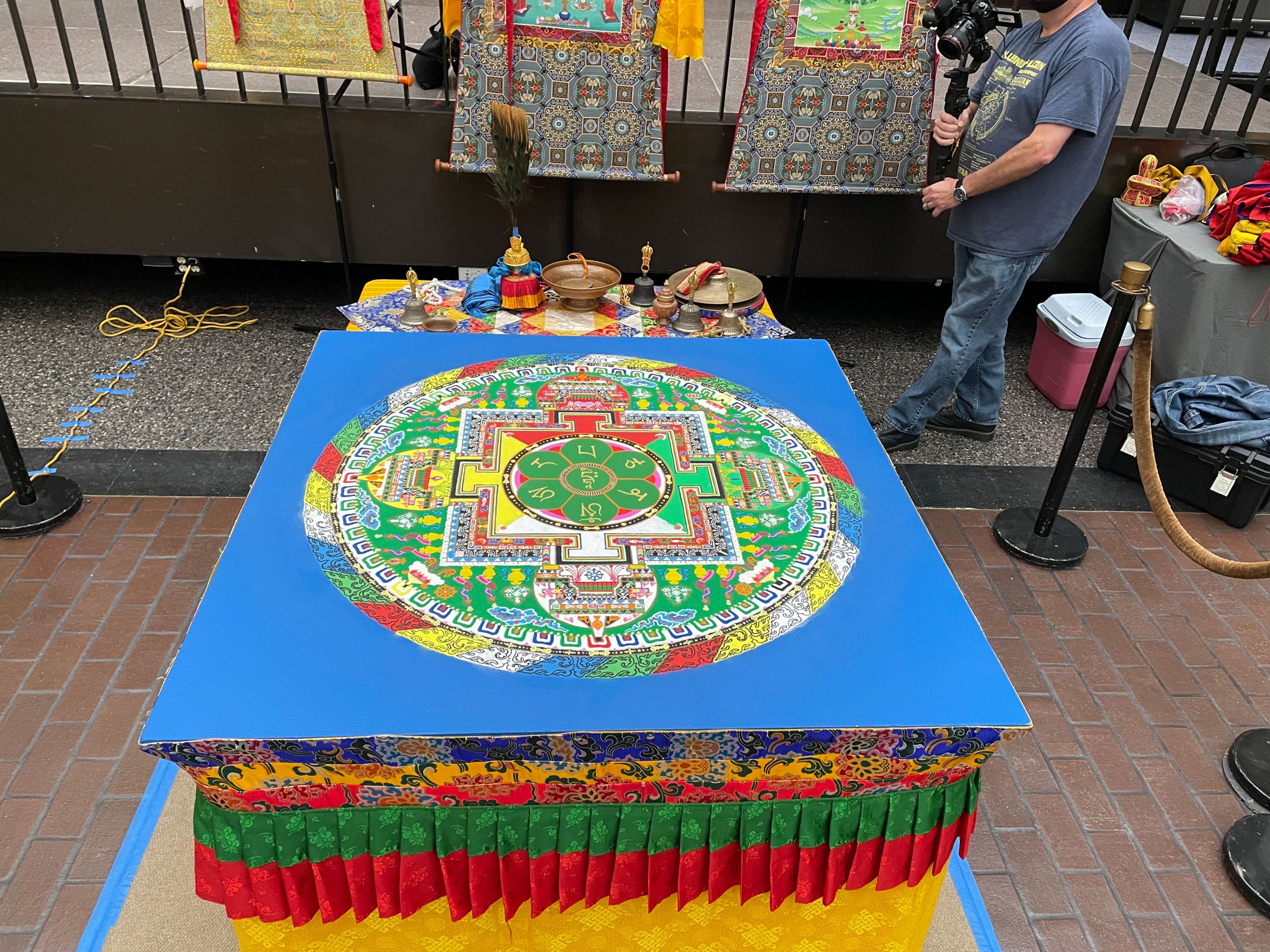PHOTO: Image depicts a Tibetan Buddhist monk sand mandala. It sits on a blue table and is multicolored. Photo by The Signal Managing Editor of Content & Operations Troylon Griffin II.