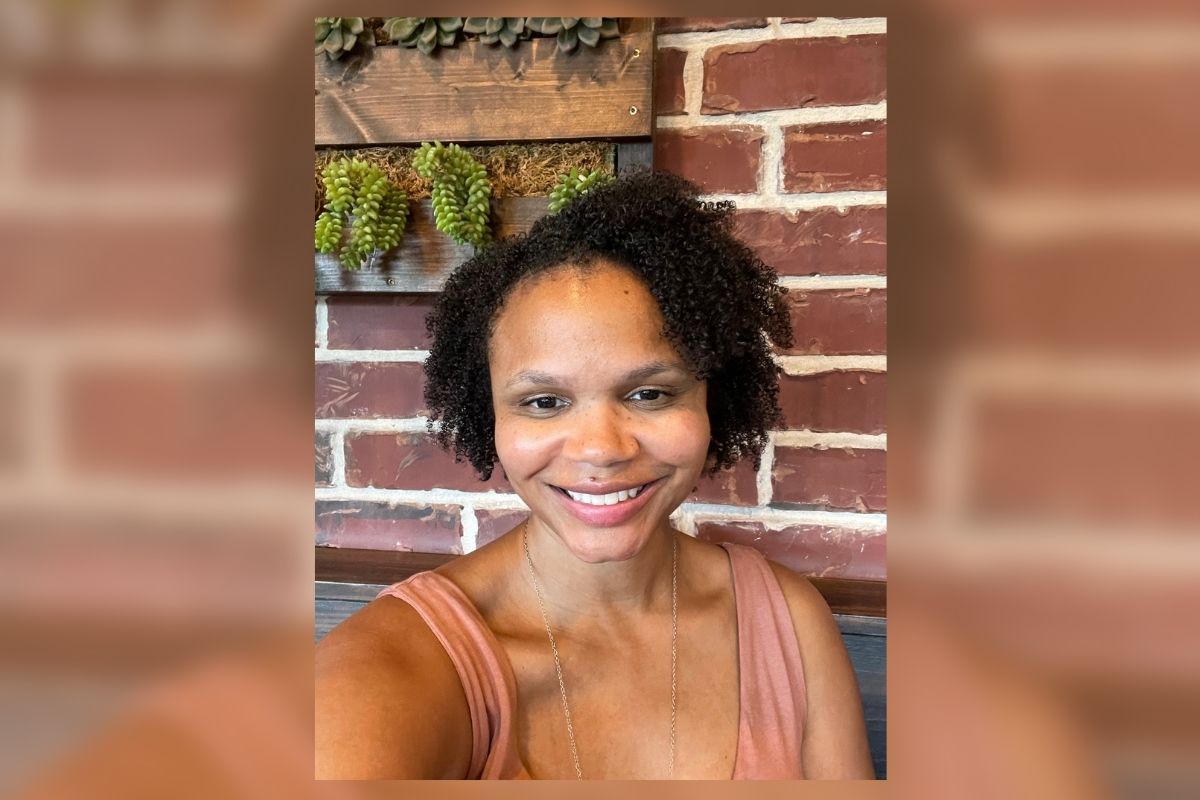 GRAPHIC: Picture of Aliya Beavers, director of the Office of Student Diversity, Equity and Inclusion. In the background, the image is blurred with an orange overlay. Photo courtesy of Aliya Beavers.