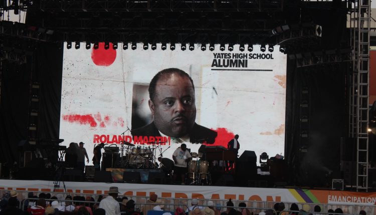 A video plays on the led screen on stage. Yates High School is a prominent school in Third Ward. We see a photo of Roland Martin, a journalist, in a white shirt black suit. Its mostly a head shot on a white background with his name written in red on the bottom left. "Yates High School Alumni" is written on the top write. Photograph by The Signal reporter Jared Cadore.
