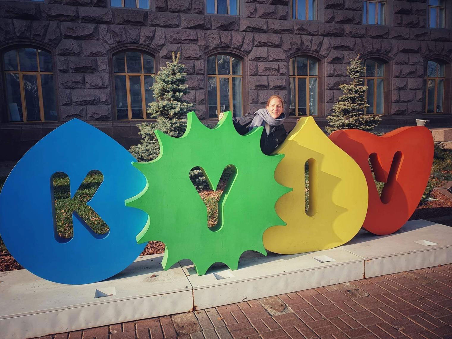PHOTO: Image shows teacher Lindsey Murff behind large letters spelling out Kyiv. Photo by Lindsey Murff.