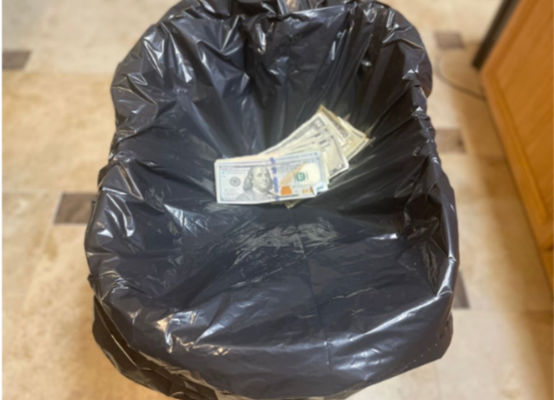 PHOTO: Four 100 dollar bills in a trash can. Photograph by The Signal Reporter Adan Martinez.