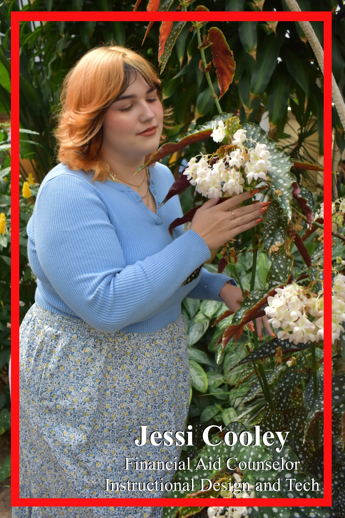 Jessi Cooley, Financial Aid Counselor and Instruction Design and Tech major, cupping white flowers in the Bayou Building botanical garden. She wears a white minidress with blue and yellow floral decals, and wears a complementing baby blue cropped cardigan to complete the look.