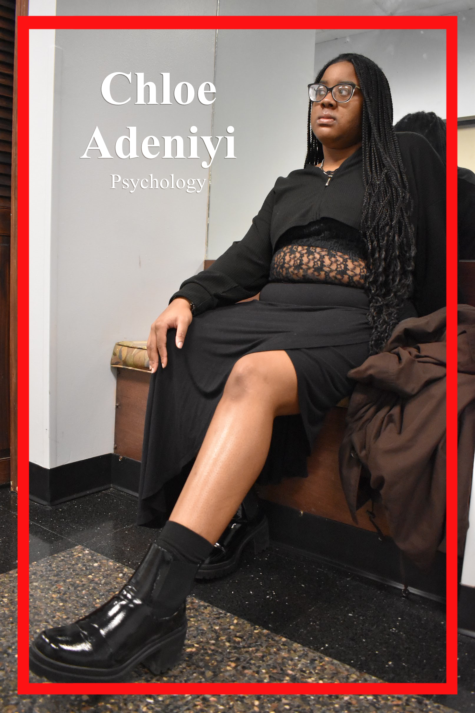 Chloe Adeniyi. Psychology Major, sitting on mirrored wall. Donned in all black from a cropped sweater, laced top, slit skirt and shiny black leather boots.
