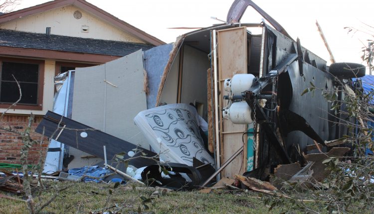 An RV in the front yard of a home in Deer Park. It is on its side and ripped open withe mattress coming out.