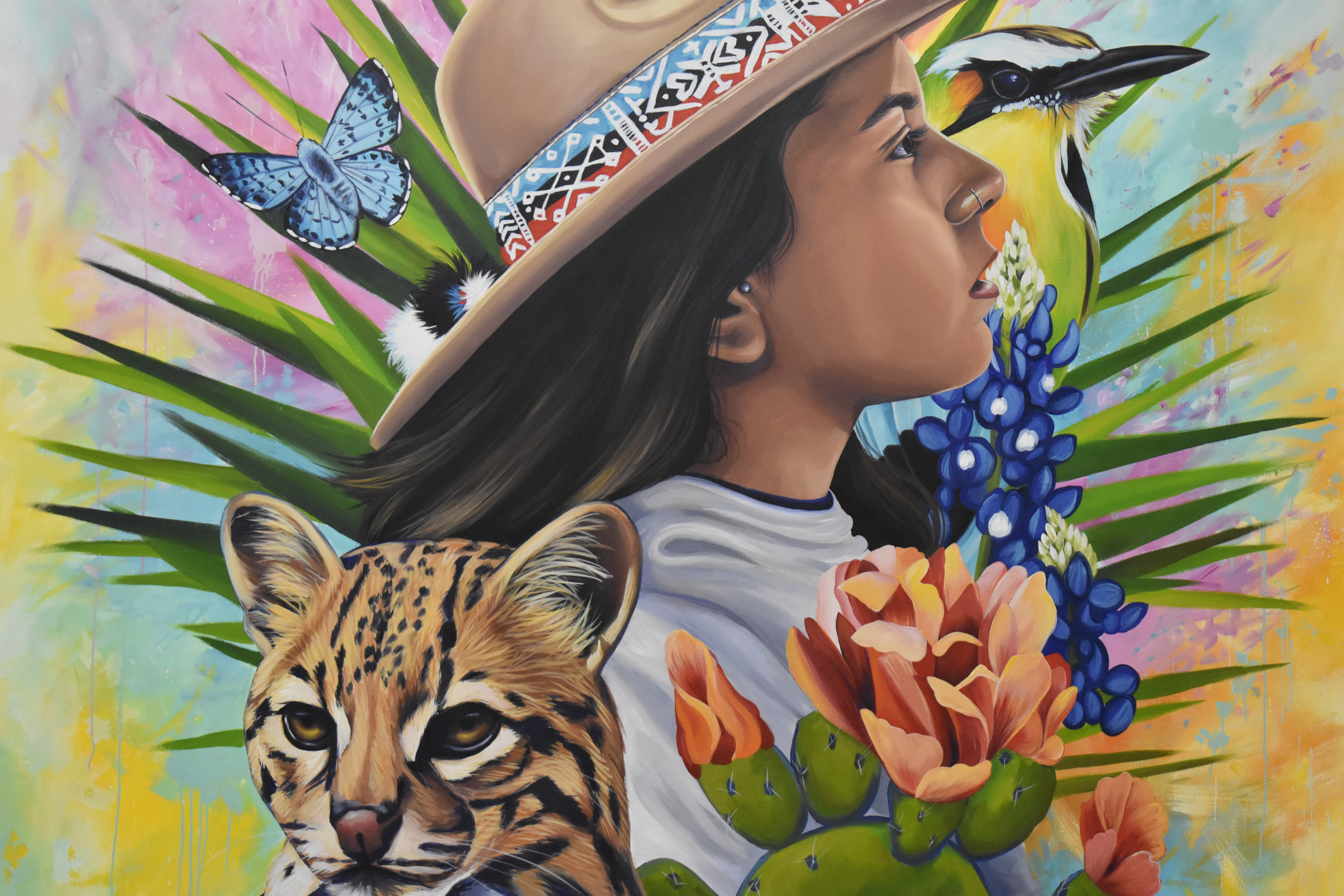 A self portrait of the artist, Elizabeth Umanzor, surrounded by colorful South American foliage and animals.