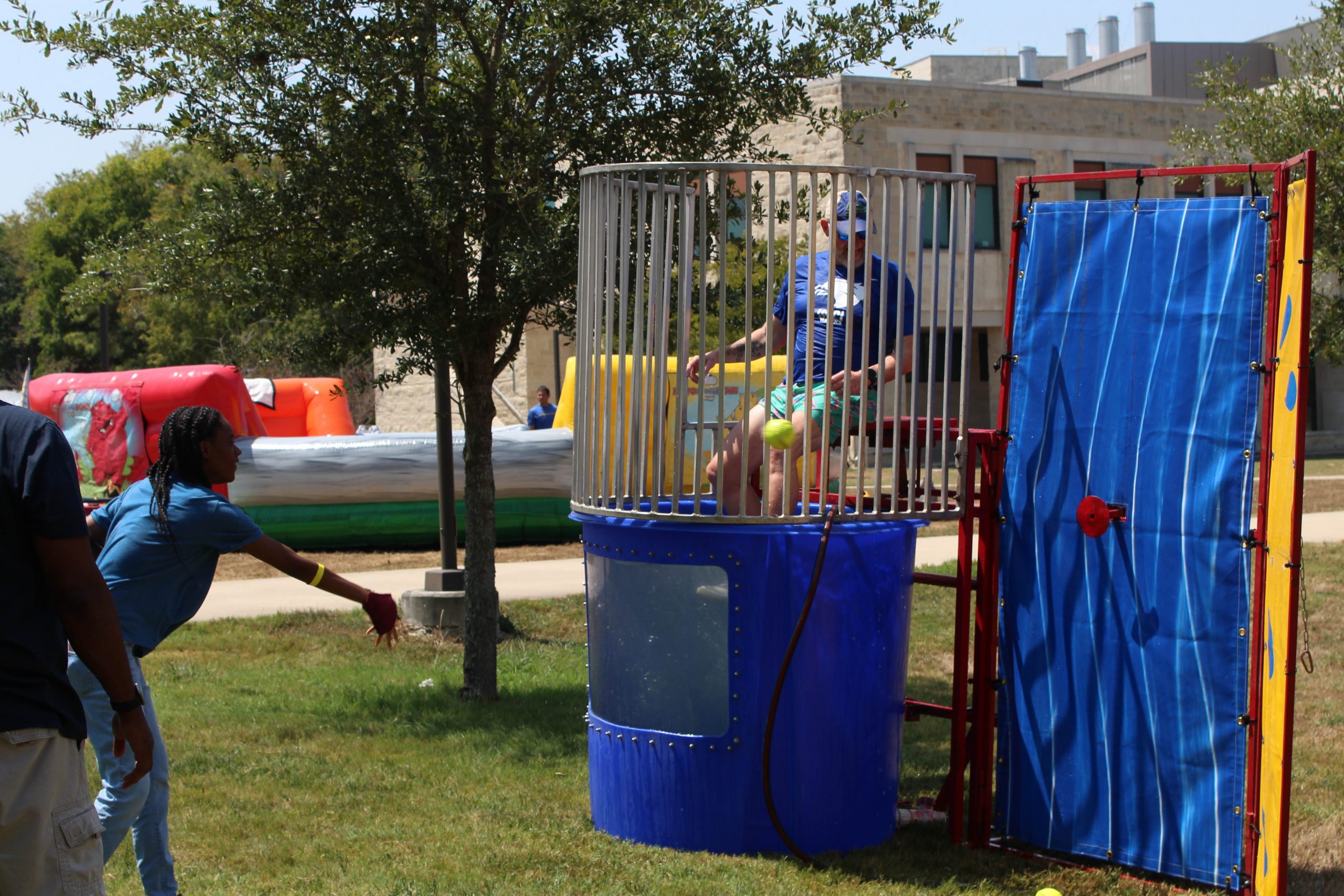 A student showing a ball to dunk a staff member in the water.