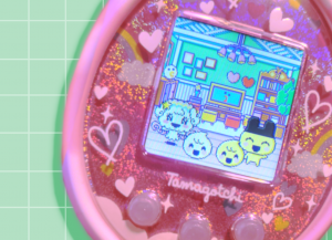 Tamagotchi On: Fairy Pink on green grid background